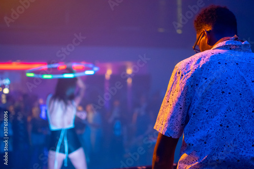 Concert shot featuring DJ, crowd, and a dancer