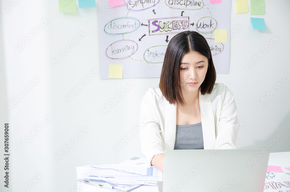 Bored asian young woman in the office working with a laptop and staring at computer screen. Hardworking for meet goal achievement in success project Bored asian young woman in the office working with a laptop and staring at computer screen. Hardworking for meet goal achievement in success project