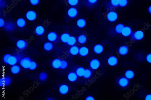 blurred night classic blue color glowing lights on black background. new year and christmas concept. color 2020