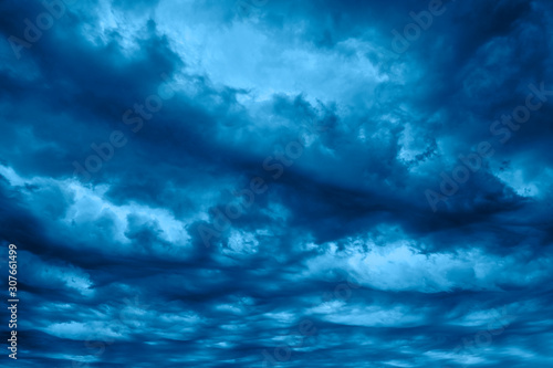 Dark blue dramatic stormy sky with grey heavy clouds. Trendy Banner with color of the year 2020