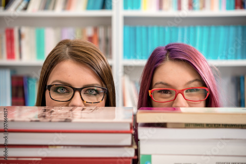Two girls posing, reading and learning in library