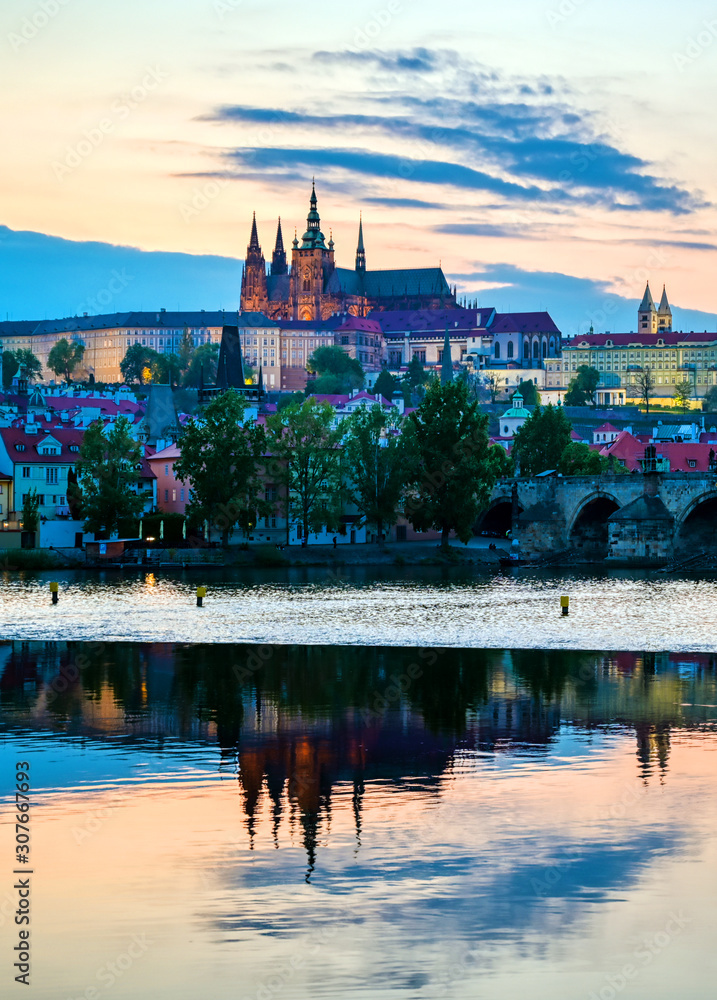 Obraz premium A view of Prague Castle and the Charles Bridge across the Vltava River in Prague, Czech Republic.