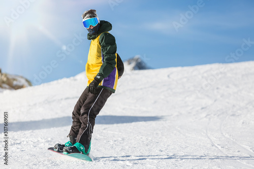 Snowboarder rides on a Board in the snow. Rest in the ski resort. Active lifestyle.