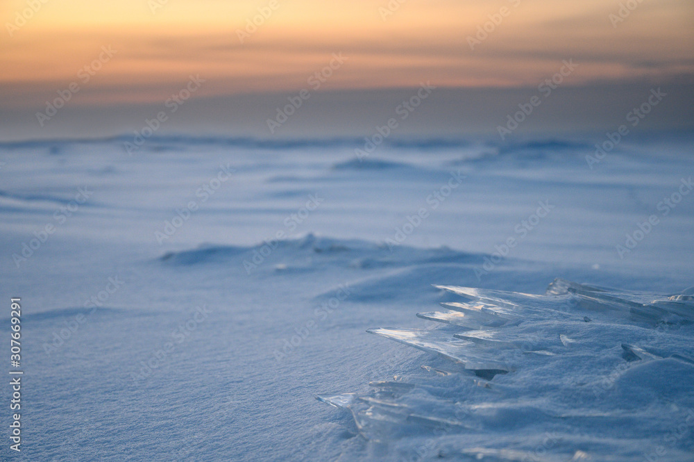 Ice plates on the surface of a frozen bay at sunset. Ice plates on the surface of a frozen bay at sunset.