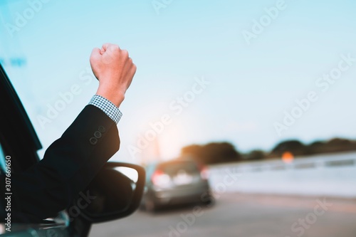 image of man in a celebrating success with a fist pump while driving in a car 