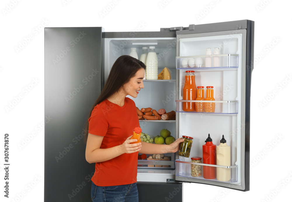 Young woman choosing products from refrigerator on white background Young woman choosing products from refrigerator on white background