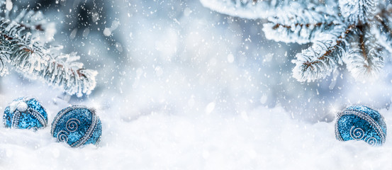 Blue christmas balls on snow with fir branches. Merry Xmas concept - panoramic banner