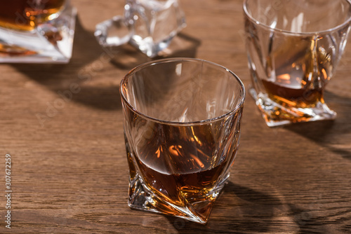 Selective focus of brandy in glasses on wooden table