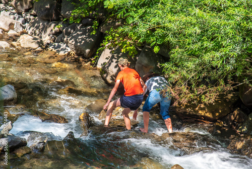 Fototapeta Naklejka Na Ścianę i Meble -  kids playing by a water creek