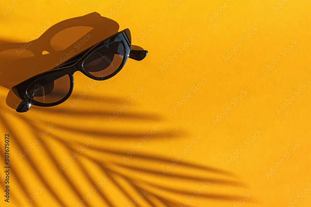 Top view hat and sunglasses on yellow background with sunlight and ...