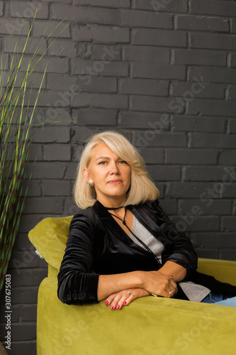 Portrait of a blond woman at a brick wall. Vertical © Nadezhda
