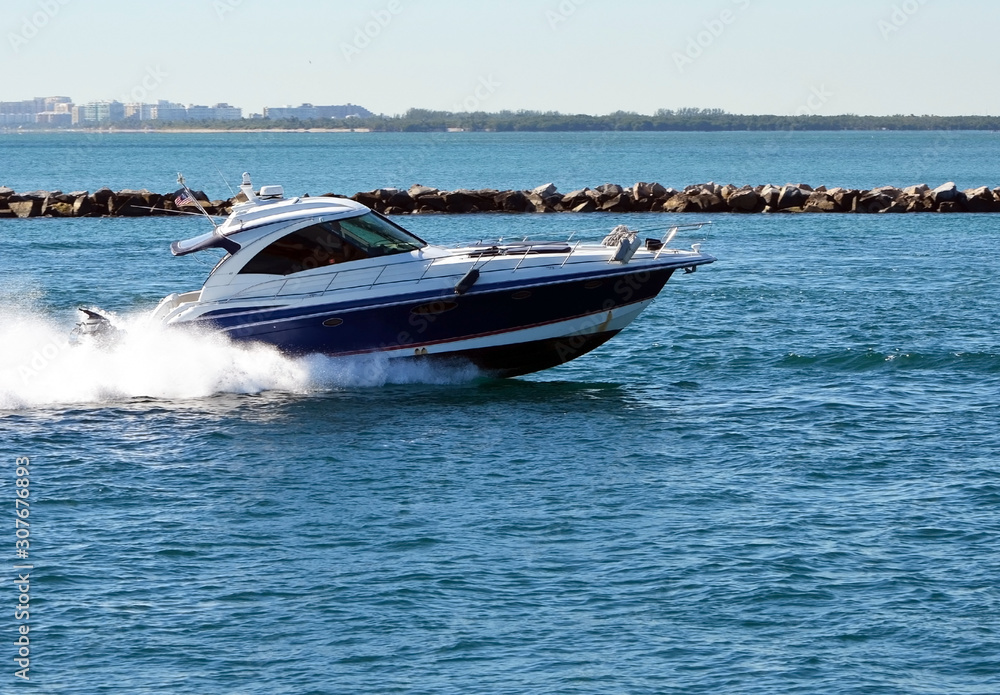 High-end cabin cruiser speeding through Government Cut off Miami Beach,Florida High-end cabin cruiser speeding through Government Cut off Miami Beach,Florida