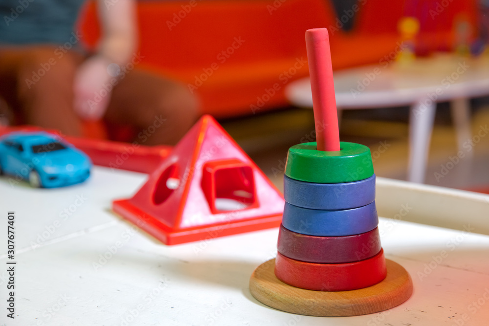 Many numbers arranged beautifully. Red round wood Captured by hand. isolated a blured background. Colorful Wooden Pyramid for Babies. Wooden toys are red, green, yellow, and blue.
