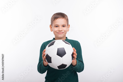 Cheerful cute little boy holding soccer ball