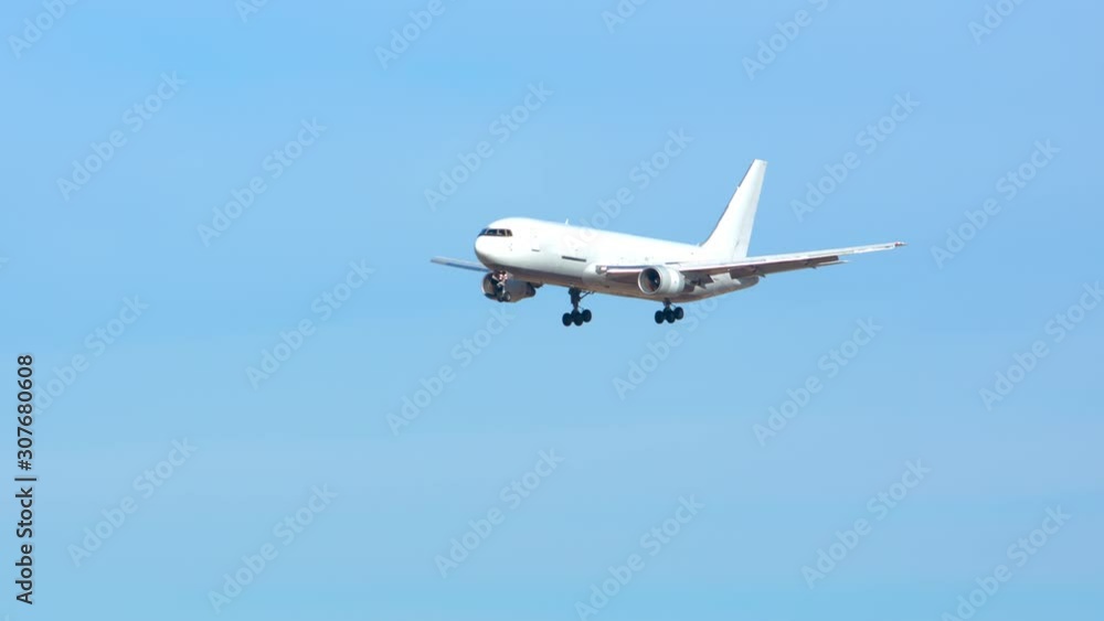 Generic Air Cargo Freighter Airplane Flying in a Blue Sky over Mountains during Final Approach on a Sunny Day Generic Air Cargo Freighter Airplane Flying in a Blue Sky over Mountains during Final Approach on a Sunny Day