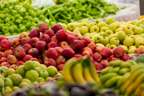 Fototapeta Naklejka Na Ścianę i Meble -  Red, green, yellow apples and other fruits on display at farmer's market