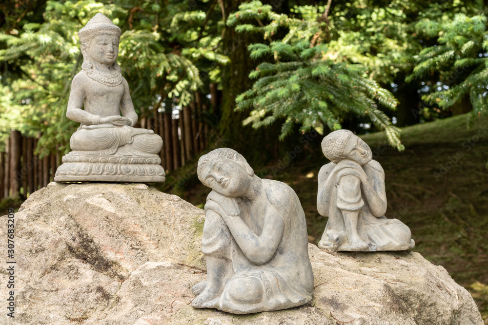 three stone buddha statues on top of a rock three stone buddha statues on top of a rock