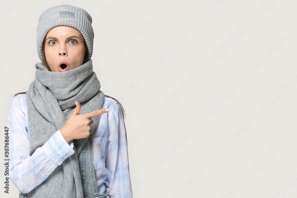 Surprised millennial woman showing aside with finger to copyspace Surprised millennial woman showing aside with finger to copyspace