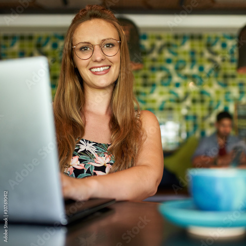 Bild auf Leinwand Attractive millennial woman smiling happily while working in boh