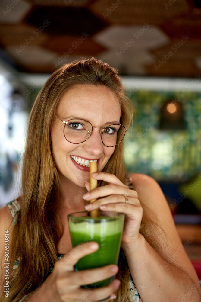 Beautiful young millennial woman drinking green superfood smooth Beautiful young millennial woman drinking green superfood smooth