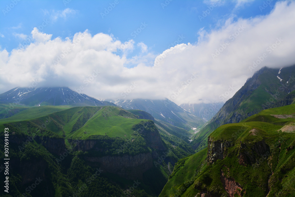 View of Kazbegi, Cross Pass, Georgia. Beautiful views of the mountains with snowy peaks on summer. Natural mountain background. Georgian military road.