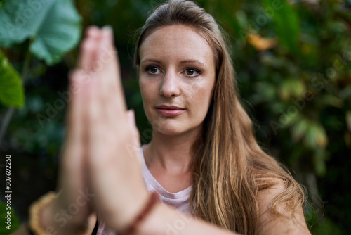 Attractive millennial woman alone in anjali mudra yoga position