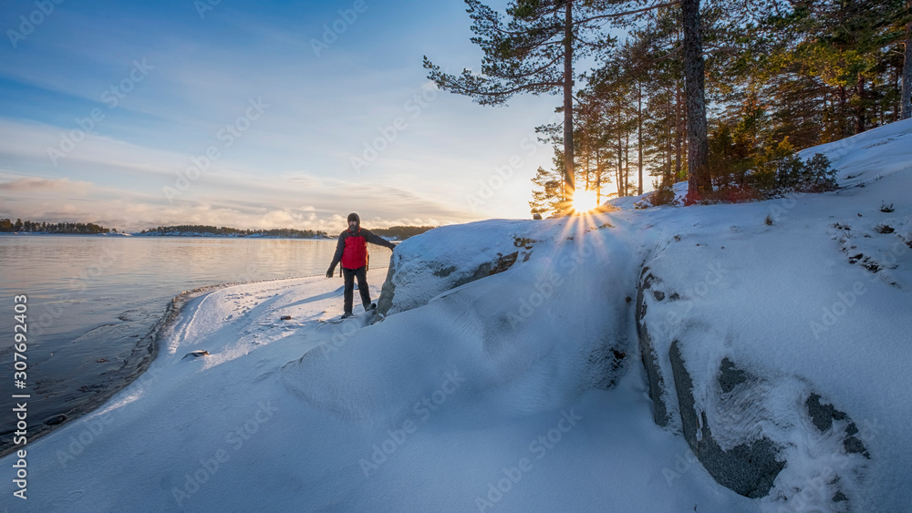 Male tourist on the shore of Lake Ladoga in winter Karelia on a bright sunny frosty day with fresh snow Male tourist on the shore of Lake Ladoga in winter Karelia on a bright sunny frosty day with fresh snow