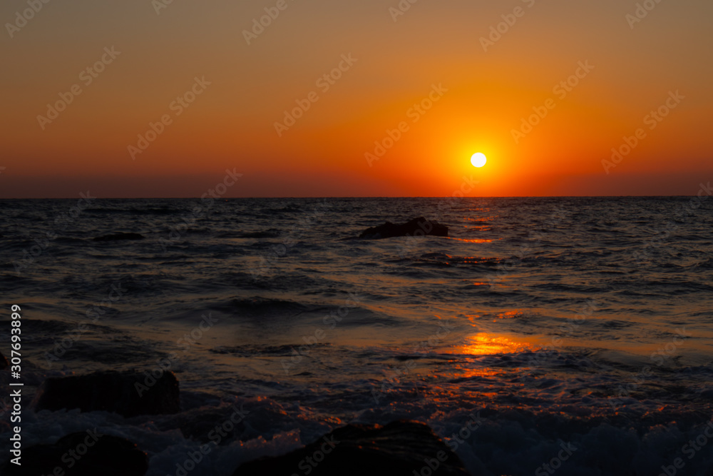 orange red sunrise at the wavy beach