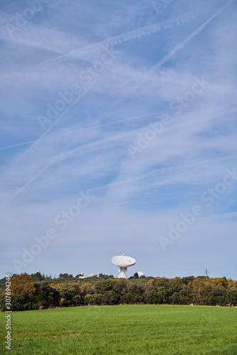 Antena astronómica situada en un campo de dehesa verde