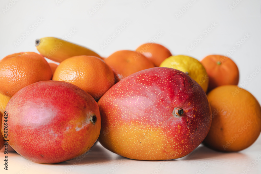 Still-life of mango and citrus close up on white background, isolated. Fruits look tasty and are lode of dopamine and vitamins, especially in winter. Natural products and healthy food concept, macro Still-life of mango and citrus close up on white background, isolated. Fruits look tasty and are lode of dopamine and vitamins, especially in winter. Natural products and healthy food concept, macro