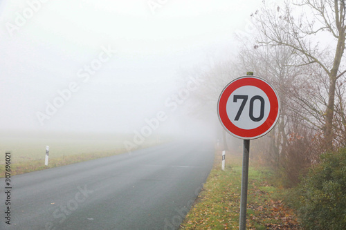 Straße im Nebel mit Geschwindigkeitsbegrenzung 70 km/h