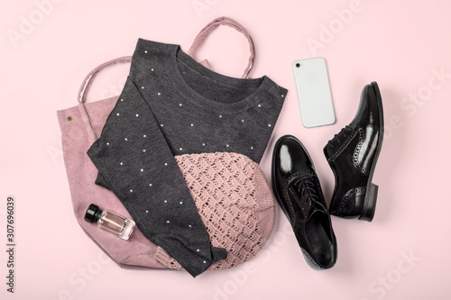 Casual female clothes and accessories on pastel pink background. Fashion flat lay. Top view.