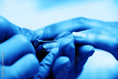 Manicure process in beauty salon  close up with blue toned