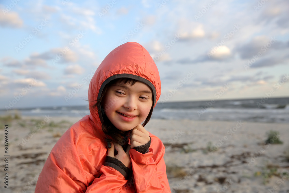Portrait of down syndrome girl smiling on background of the sea Portrait of down syndrome girl smiling on background of the sea