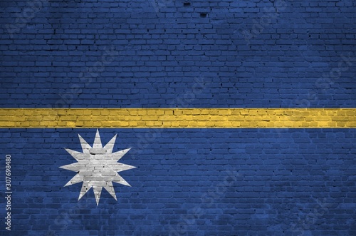 Nauru flag depicted in paint colors on old brick wall. Textured banner on big brick wall masonry background photo