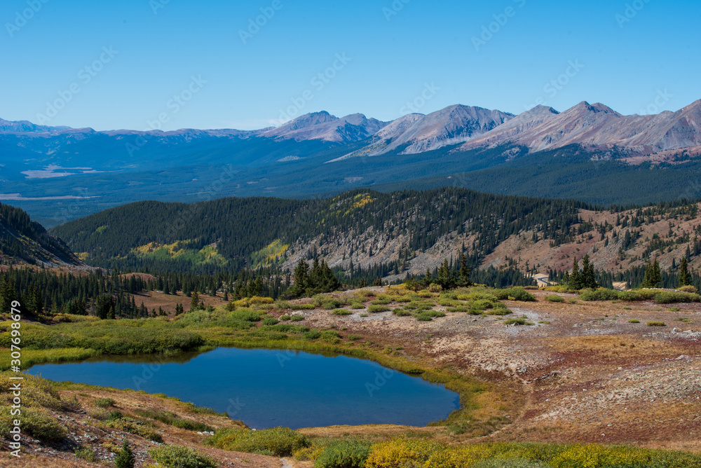 Landscape of small pond, trees and mountain tops at Cottonwood Pass in Colorado