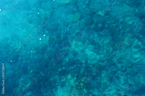 photo of the seabed with pebbles through clear water. surface as background