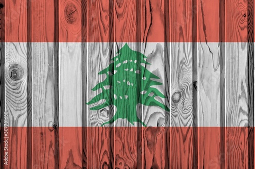 Lebanon flag depicted in bright paint colors on old wooden wall. Textured banner on rough background photo