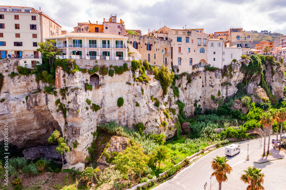 Famous sea promenade in Tropea with high cliffs with built on top city buildings and apartments. Parking area on the street. Amazing Italian city