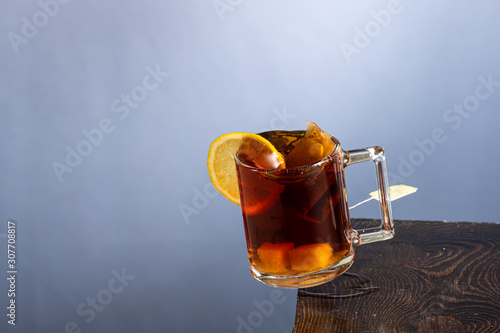 falling mug with tea or coffee on the edge of the table and splashes on a gray background