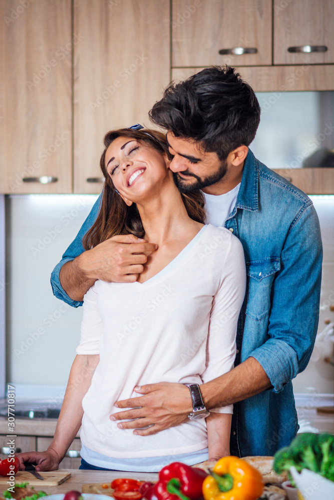 Obraz premium Happy couple showing affection in the kitchen.