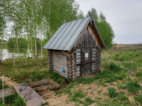 old small wooden house on a background of birches