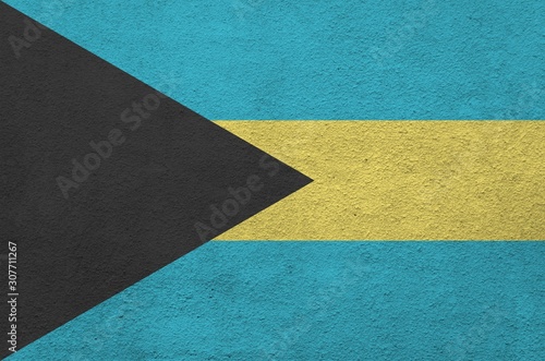 Bahamas flag depicted in bright paint colors on old relief plastering wall. Textured banner on rough background photo