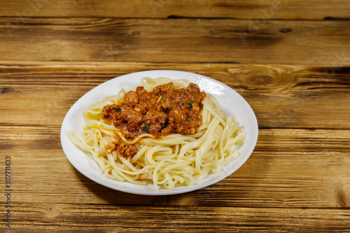 Pasta with bolognese sauce on wooden table