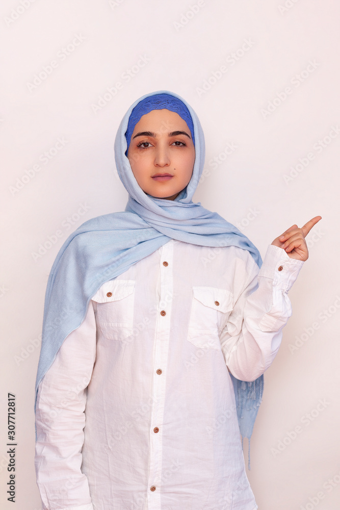 Portrait of stylish Iranian woman. Elegant Muslim woman in hijab pointing with hands to empty space. Copy space for your text. Beautiful Muslim female isolated Portrait of stylish Iranian woman. Elegant Muslim woman in hijab pointing with hands to empty space. Copy space for your text. Beautiful Muslim female isolated