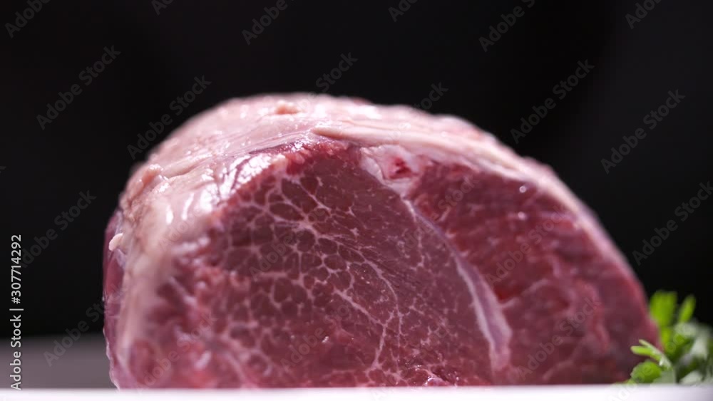 Raw marbled meat cut of beef rotating dark background Raw marbled meat cut of beef rotating dark background