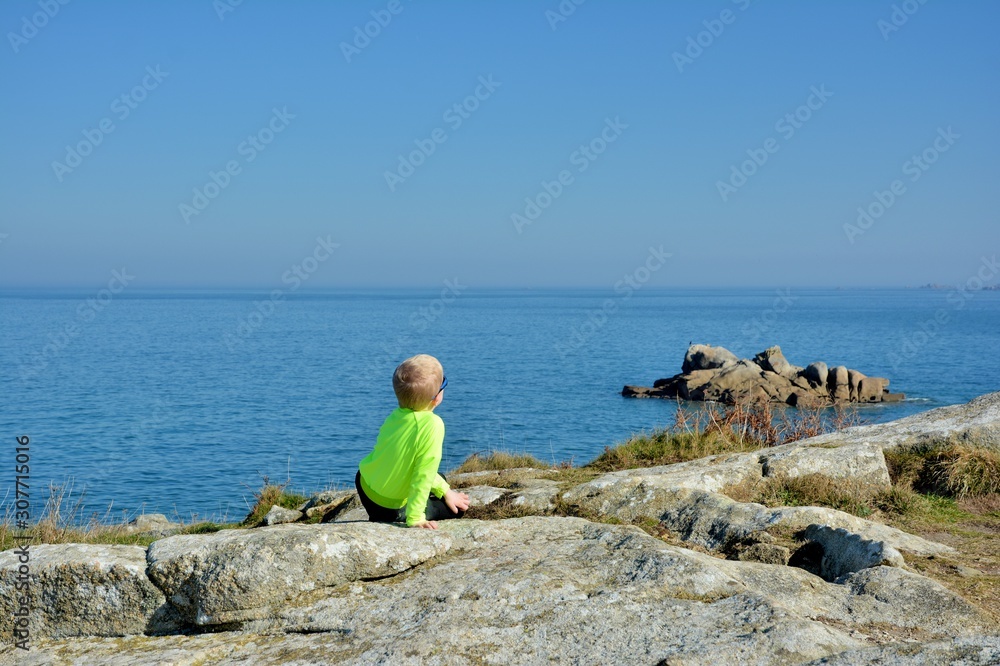Young boy who is watching the sea in Brittany. France