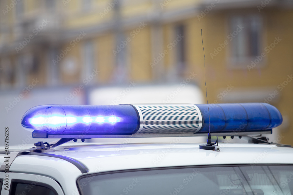 brightly glowing blue flashing light with a police car siren