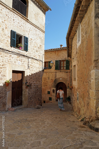 Young turist girl walks down picturesque street of Valldemossa. Majorca  Spain