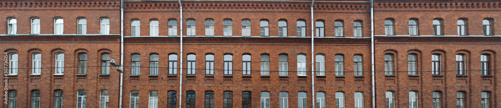 Panorama of the facade of an old brick apartment building as a background